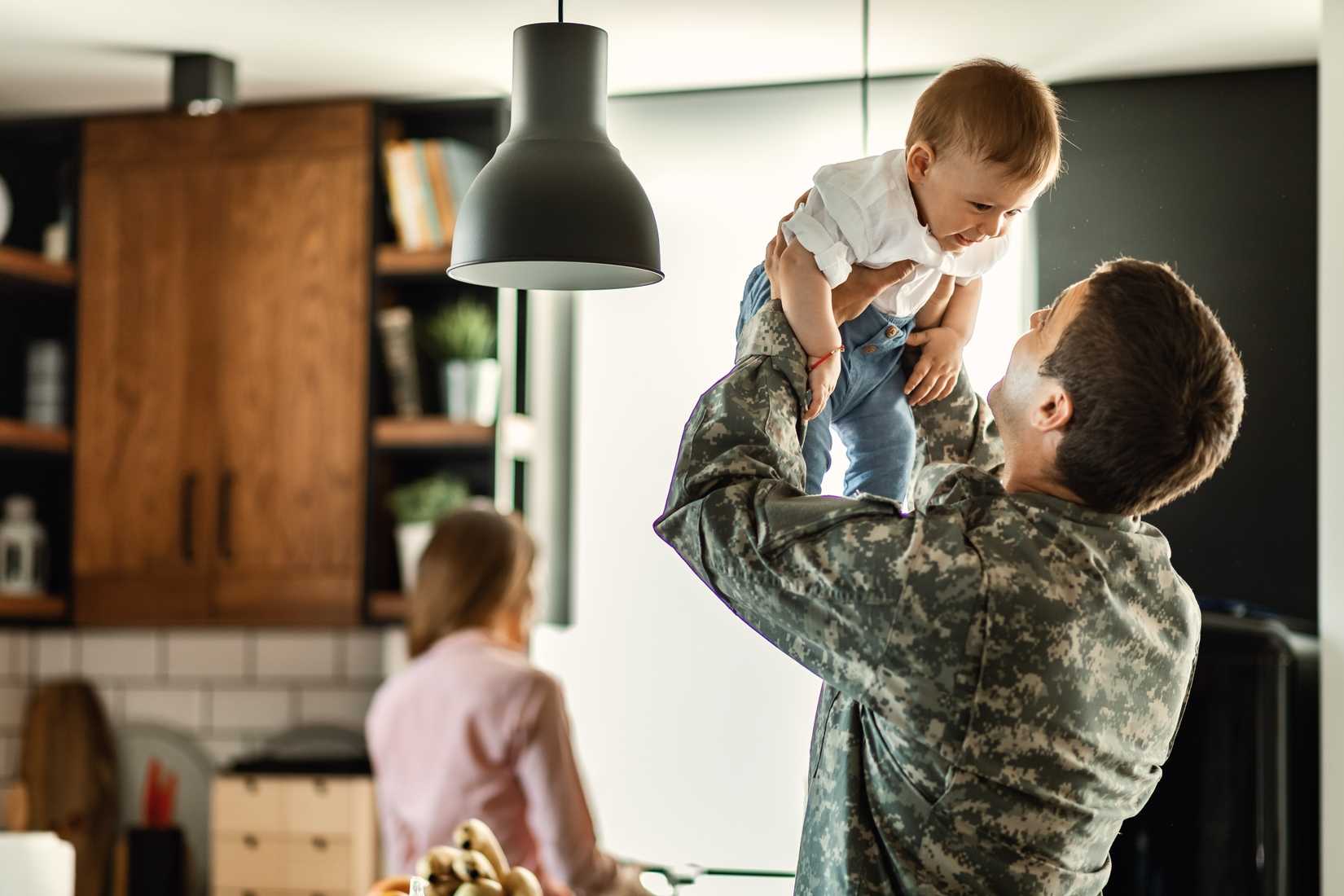 happy-baby-boy-having-fun-with-his-military-dad-home-mother-is-background.jpeg