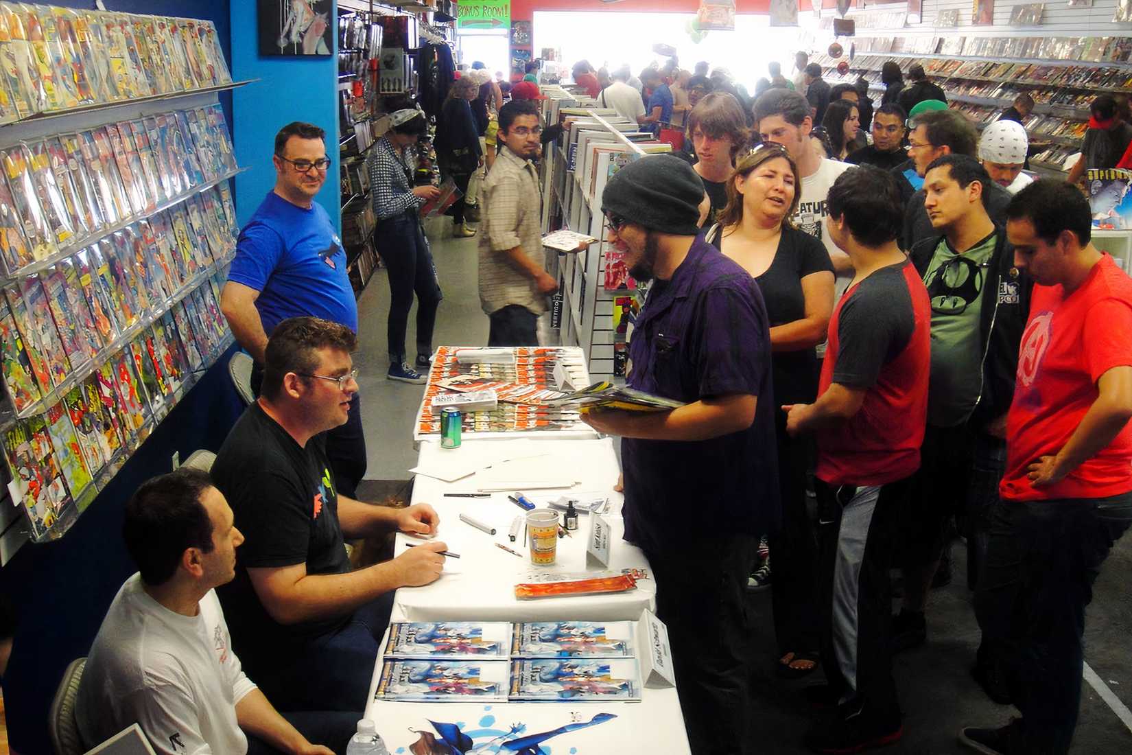 Large crowd inside a comic book store during a busy event with people browsing and waiting in line