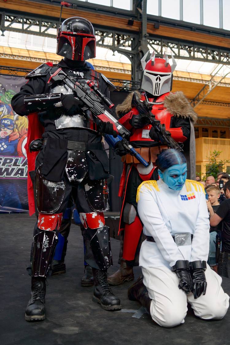 People dressed in Star Wars cosplay costumes posing at a convention-style event