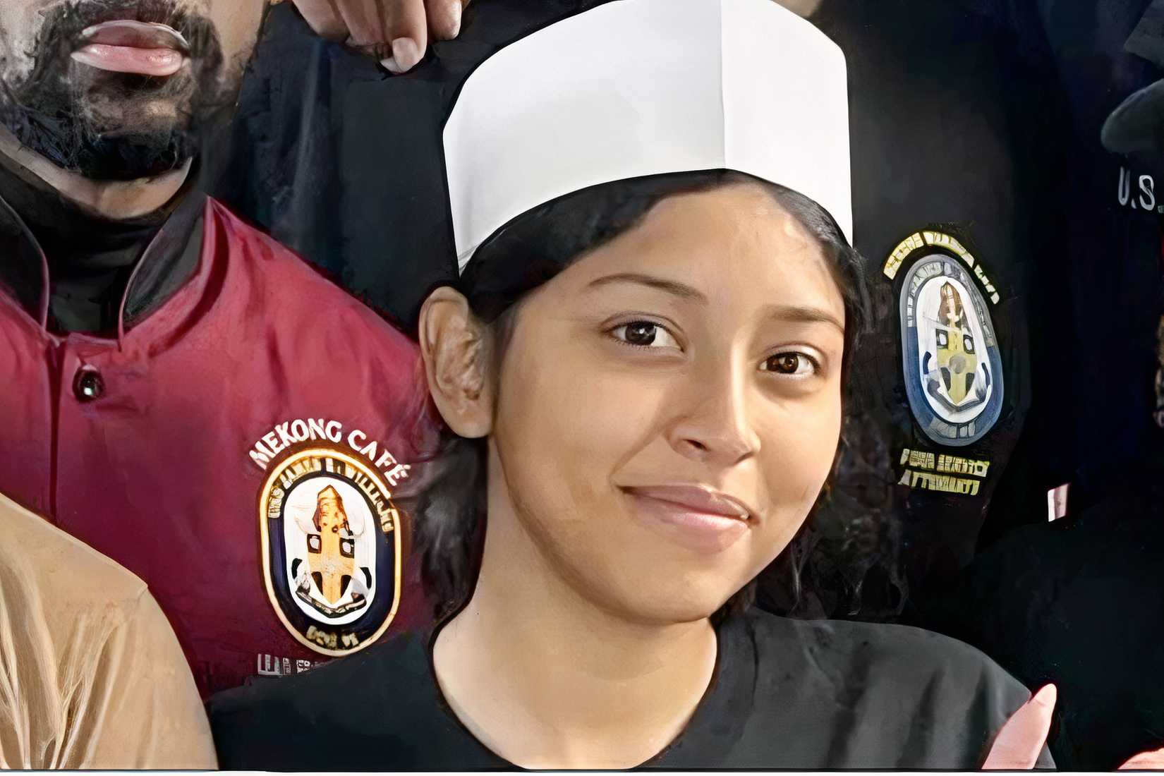 Navy Seaman Angelina Resendiz smiles while wearing a sailor cap in a culinary setting.