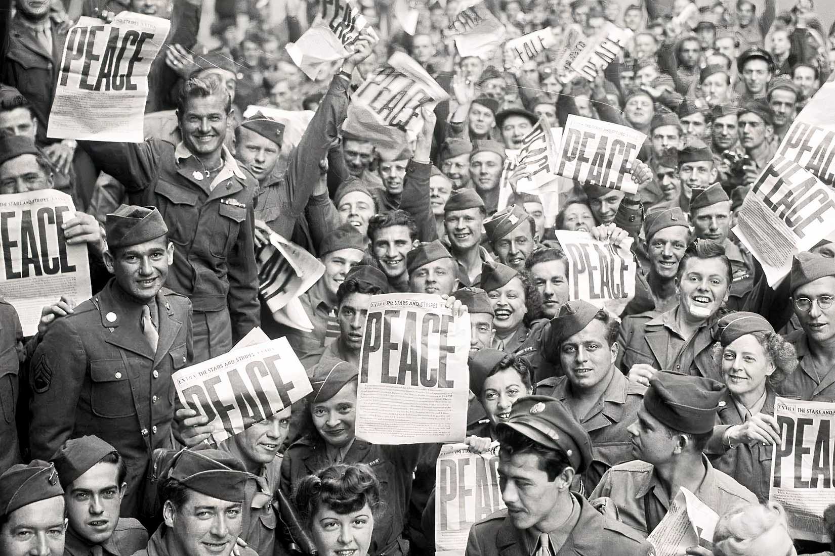 U.S. soldiers celebrate V-E Day in 1945 while holding copies of the Stars and Stripes newspaper.