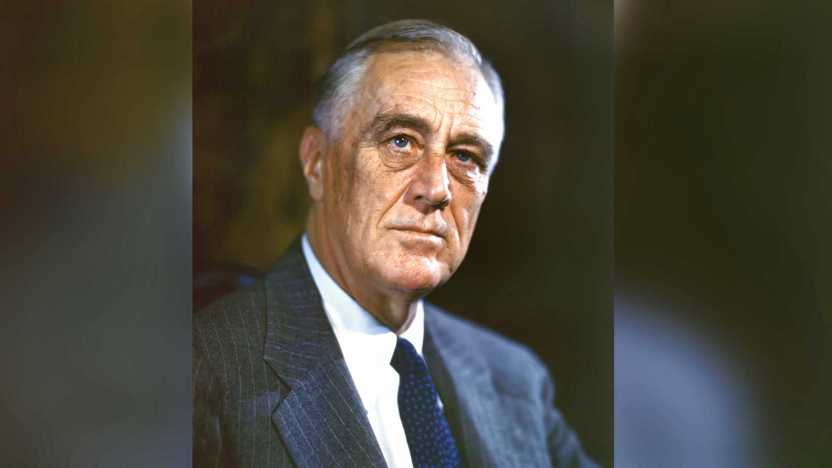 A color portrait of President Franklin D. Roosevelt wearing a suit and tie.