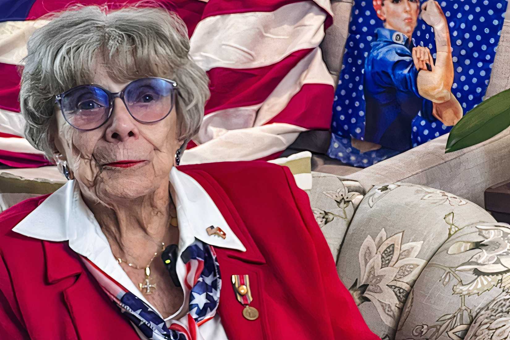 Roberta “Randy” Tidmore, a World War II Marine veteran and Rosie the Riveter, sits in front of patriotic decor.
