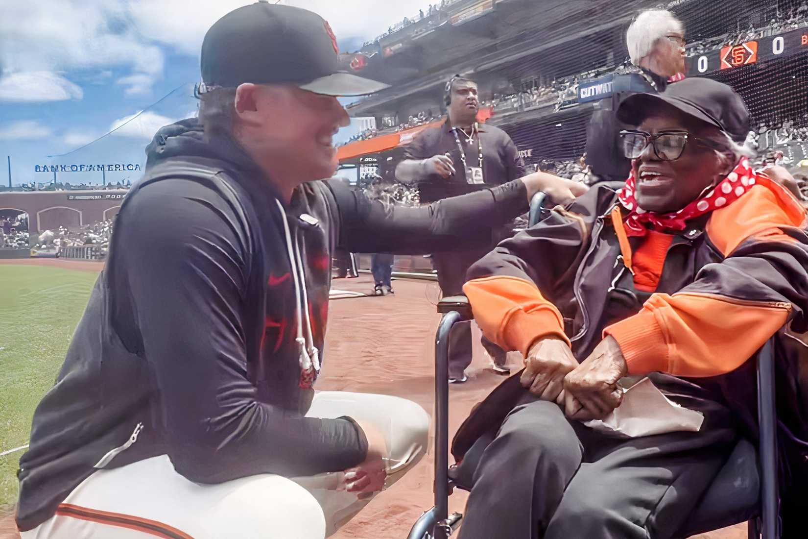 Elizabeth Tate speaks with a San Francisco Giants player during an on-field recognition.