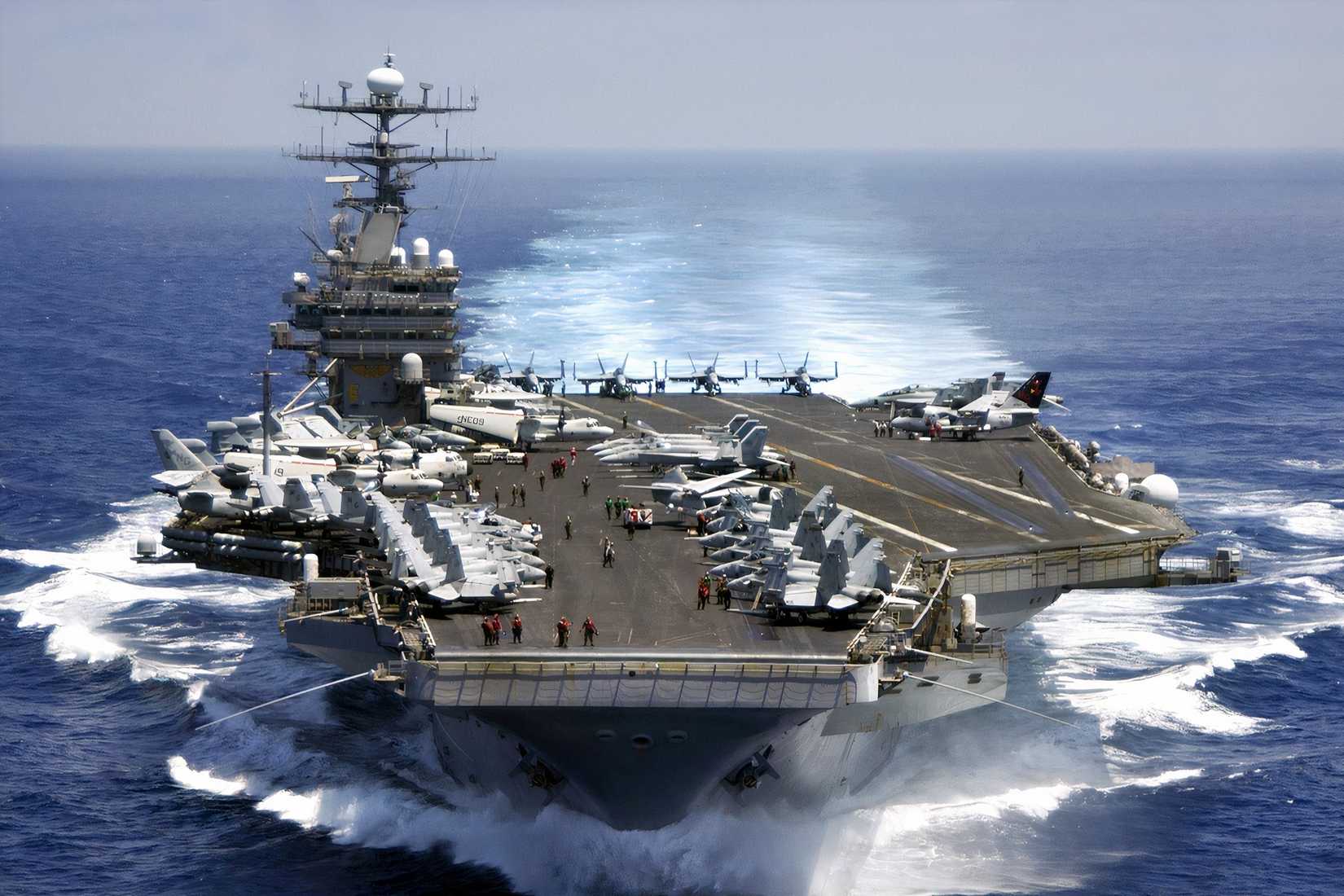 The nuclear-powered aircraft carrier USS Carl Vinson sails through the Indian Ocean with aircraft positioned on its flight deck.