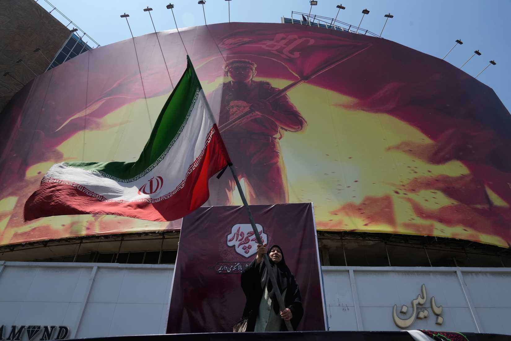 A billboard showing a graphic of a man wearing a shirt showing the face of late Iranian Supreme Leader Ayatollah Ali Khamenei.