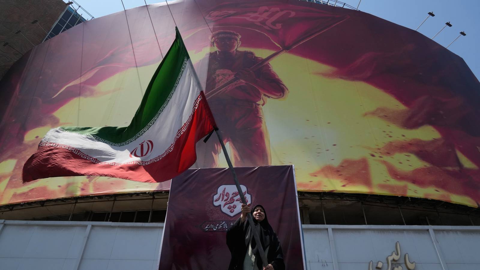 A billboard showing a graphic of a man wearing a shirt showing the face of late Iranian Supreme Leader Ayatollah Ali Khamenei.