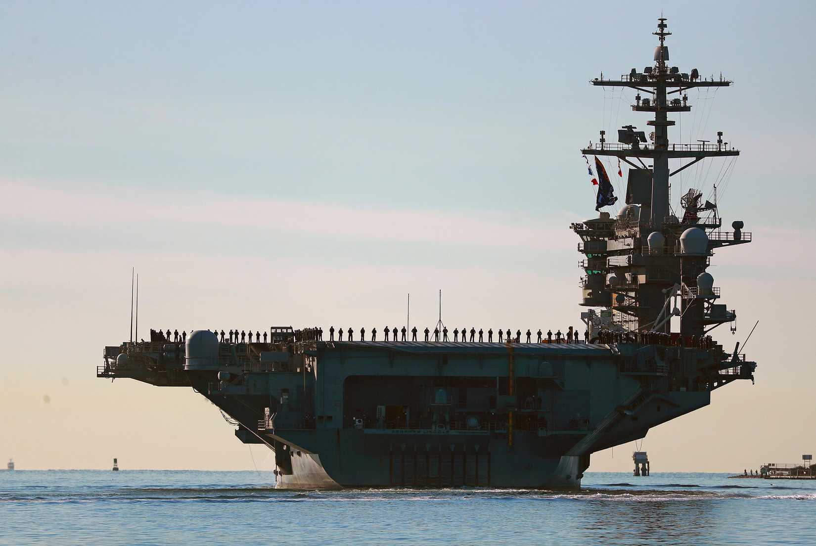 Sailors and Marines line the deck of aircraft carrier USS Abraham Lincoln.