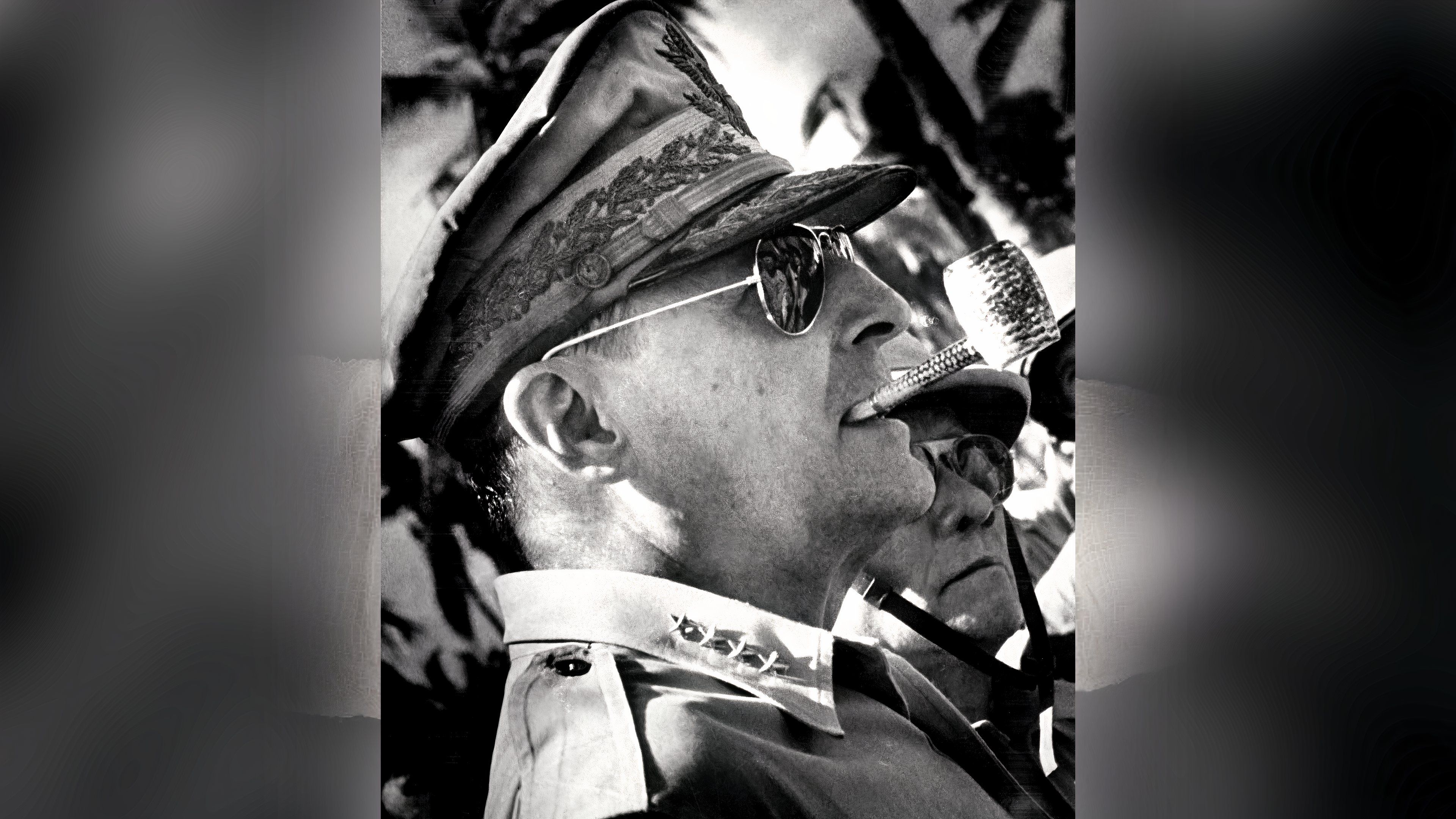 Gen. Douglas MacArthur wears aviator sunglasses and smokes a corncob pipe while surveying the Leyte beachhead in 1944.