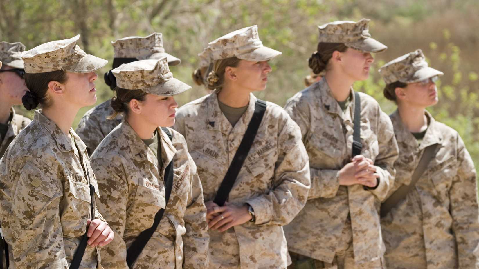 Female Marines in desert camouflage listen during Lioness Program training at Camp Korean Village, Iraq.