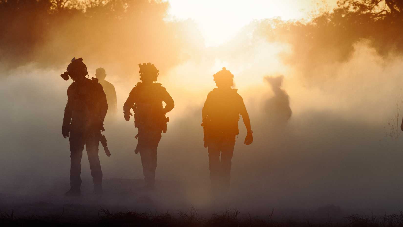 Members of a tactical team move through smoke and sunlight during a mission in Season 3 of Lioness.