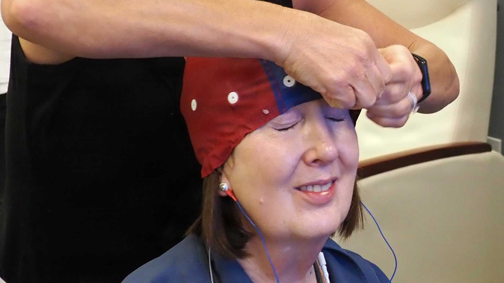 Medical staff fit a patient with an electrode cap used for neurofeedback treatment of traumatic brain injuries at Fort Carson.