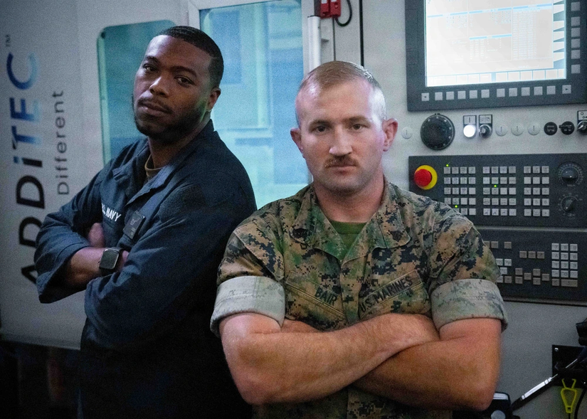 Personnel pose in front of printer