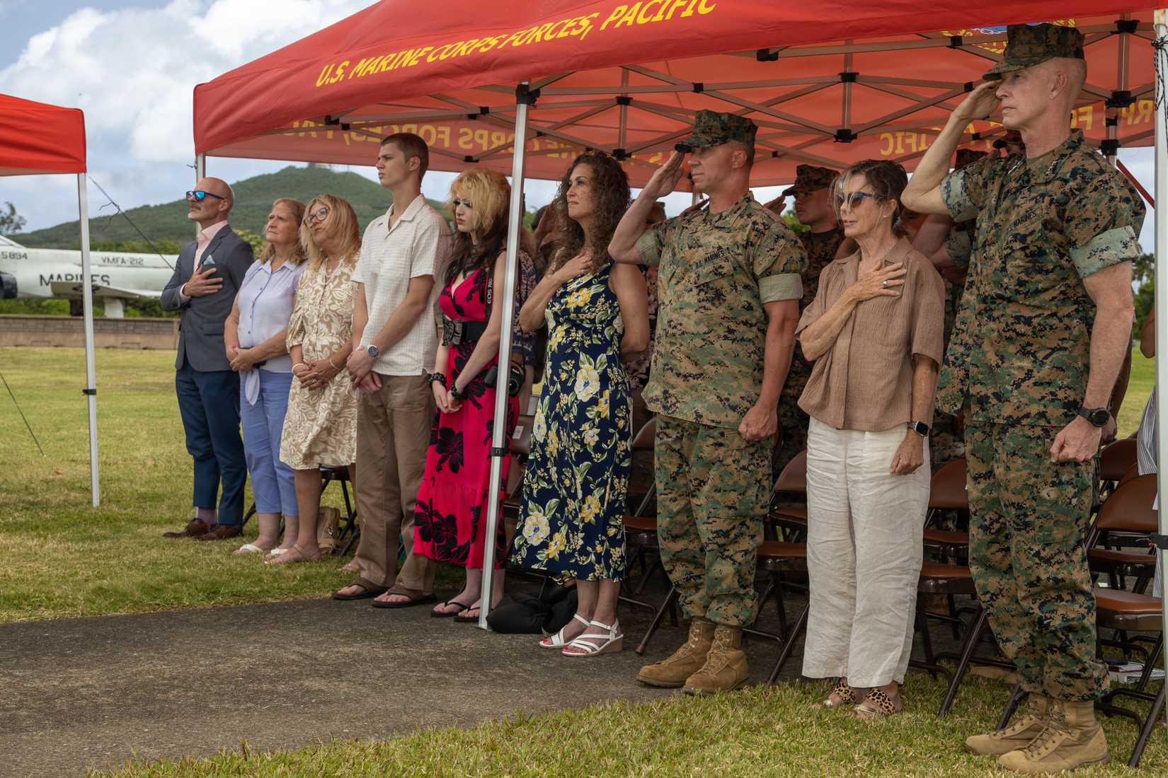 Marines and civilians stand for the national anthem during a retirement ceremony Col. Christian Devine