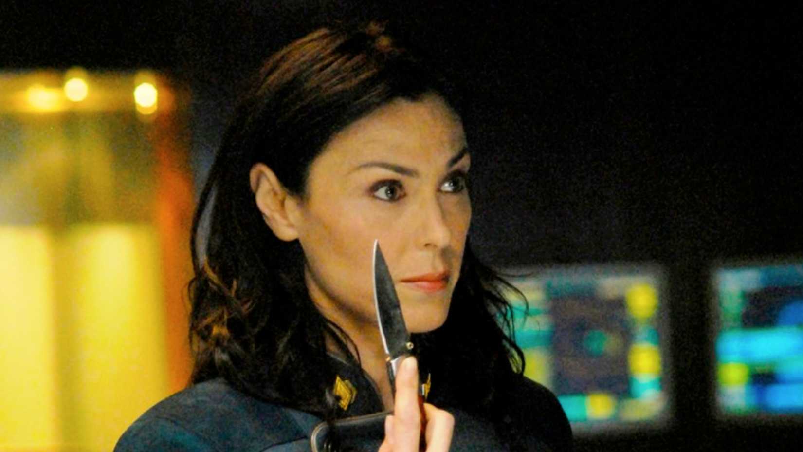 Michelle Forbes as Admiral Helena Cain holding a knife in a scene from Battlestar Galactica.