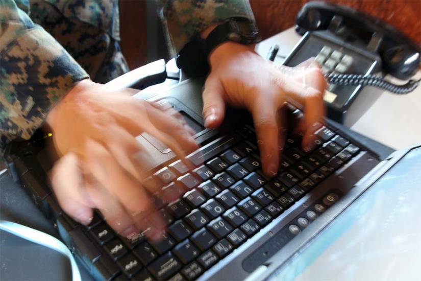 A data network specialist works to trouble-shoot a computer issue.